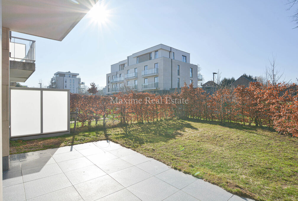 This recent apartment (2018) is located on the ground floor +/- 86m² and was built with very good energy performance (PEB A)!

The composition: entrance hall, separate toilet, living room opening onto a beautiful terrace and garden (with exclusive and pr