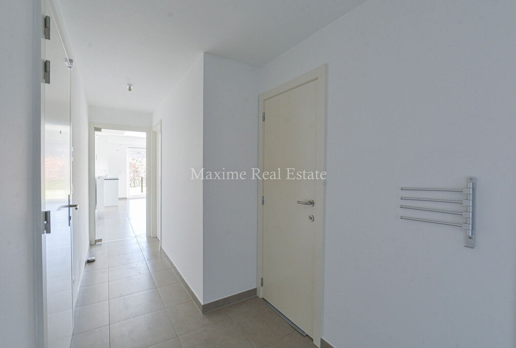 This recent apartment (2018) is located on the ground floor +/- 86m² and was built with very good energy performance (PEB A)!

The composition: entrance hall, separate toilet, living room opening onto a beautiful terrace and garden (with exclusive and pr